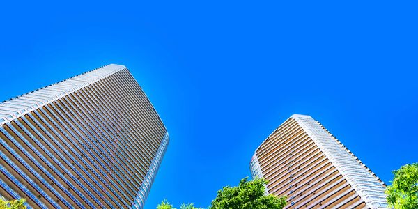 Two modern skyscrapers against a clear blue sky.