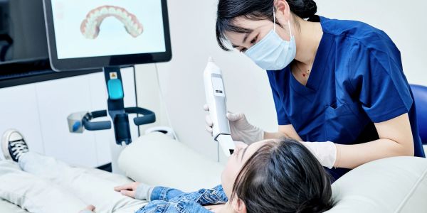 Dentist using digital scanner for dental impression.