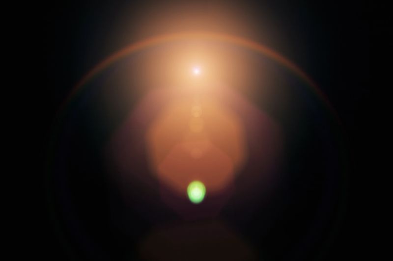Lens flare on black background. Overlay design element