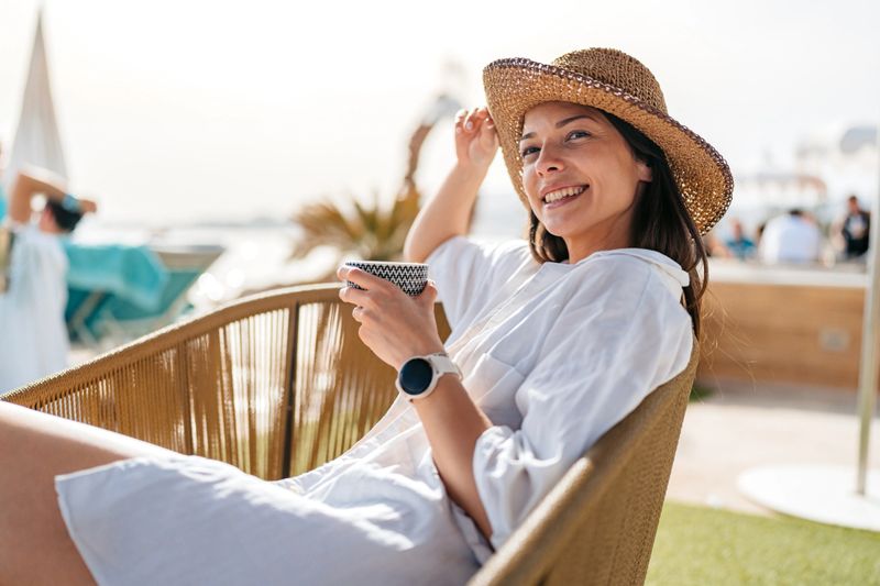 Young woman drinking coffee in a beach bar in Palma de Mallorca in Spain.