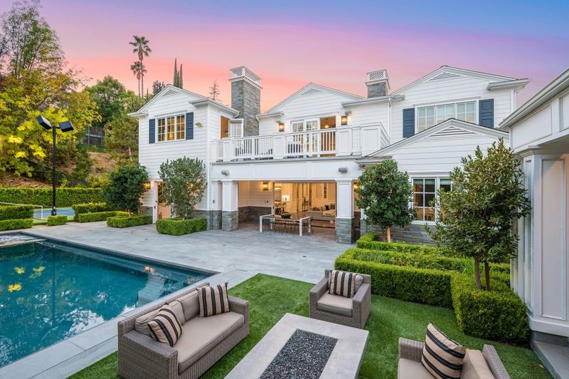 A large pool in front of a white house in Encino, California
