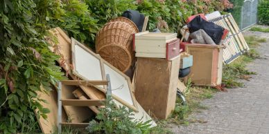 Discarded furniture and household items piled on the sidewalk.