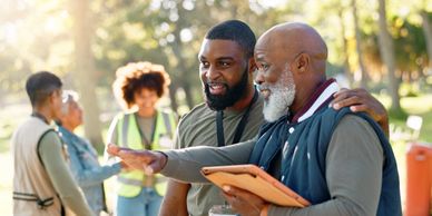 two African American men having a conversation with arm around the elder man