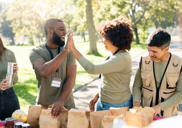 Volunteers giving high five at a community event.