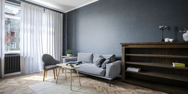 picture of feature wall with wood cabinet and gray couch and white curtains with new paint