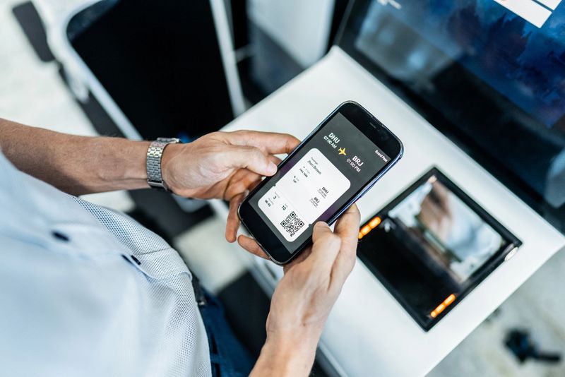 Close-up of man doing self service check-in with mobile phone at the airport