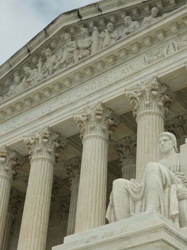 Architectural detail of the Supreme Court building with columns and statues.