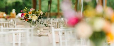 Elegant floral centerpiece on a white decorated table at an event.