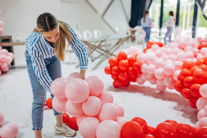The event decorator makes a huge decoration out of balloons, tying them together and making a column out of them
