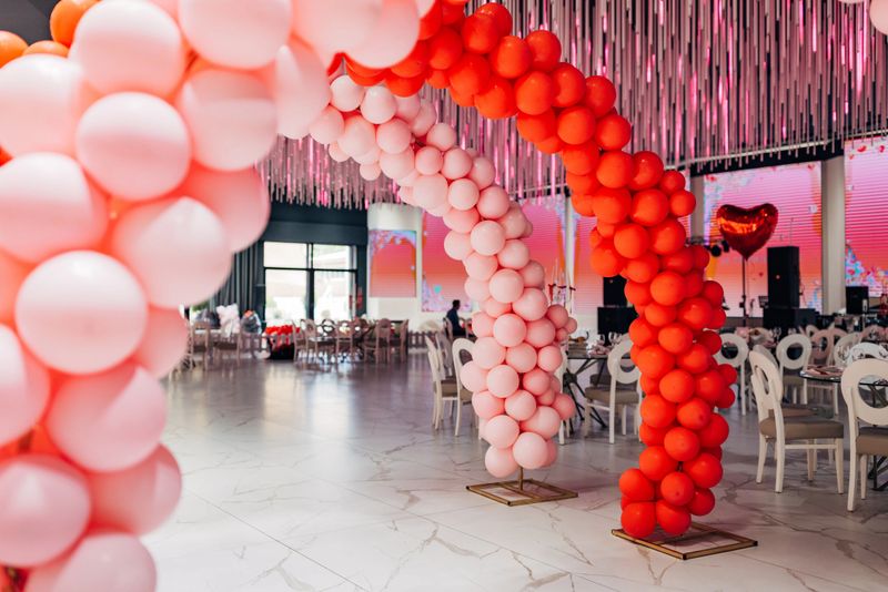 Beautiful decoration in the restaurant hall, two-color balloon arch and heart-shaped balloons arranged all over the restaurant hall