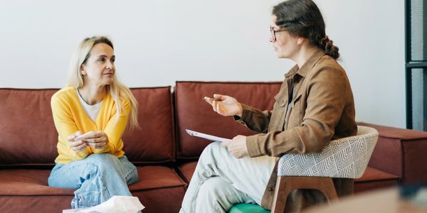 Two women engaged in a serious conversation in a cozy room.