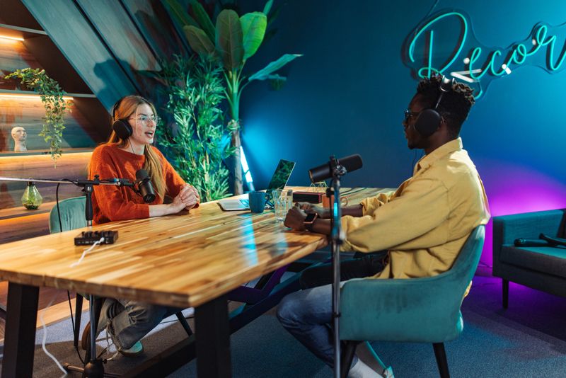 Intimate moment during a podcast recording between man and woman deeply involved in conversation.