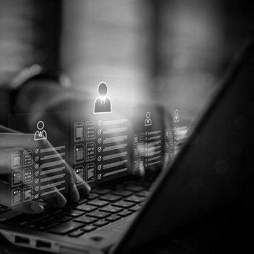 Hands typing on a laptop with digital resumes floating above the keyboard.