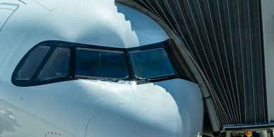 Close-up of an airplane cockpit connected to a boarding bridge.