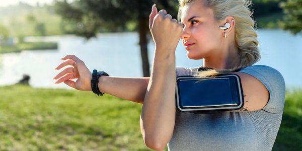  woman stretching in the garden with headphones on.