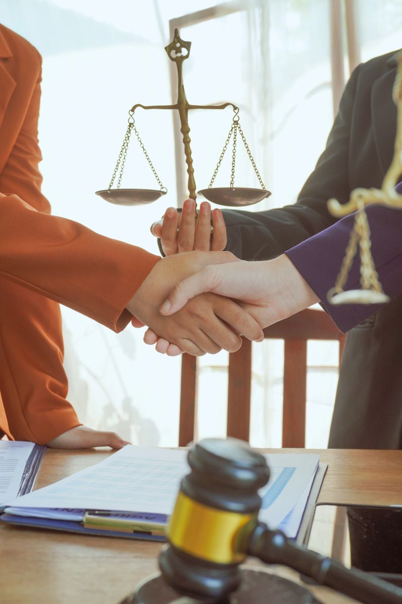 Shaking hands, A group of lawyers and clients engage in a professional meeting at a law office, discussing agreements, contracts, and legal matters with a focus on justice and expert advice.