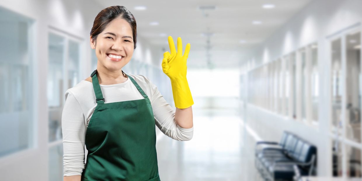 Female cleaner in uniform showcasing reliable office and business cleaning