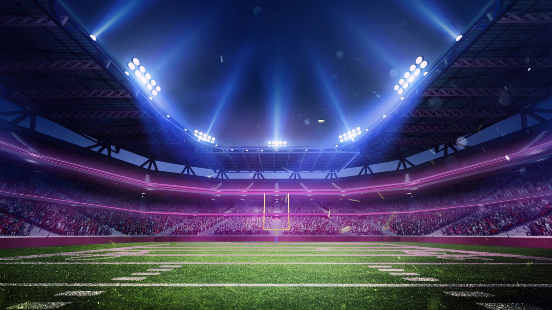Nighttime football stadium with bright floodlights and a cheering crowd.