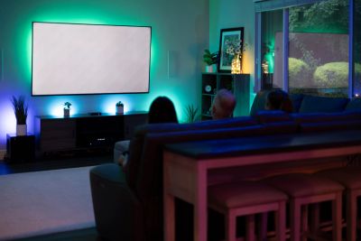 Family enjoying a movie with popcorn and remotes.