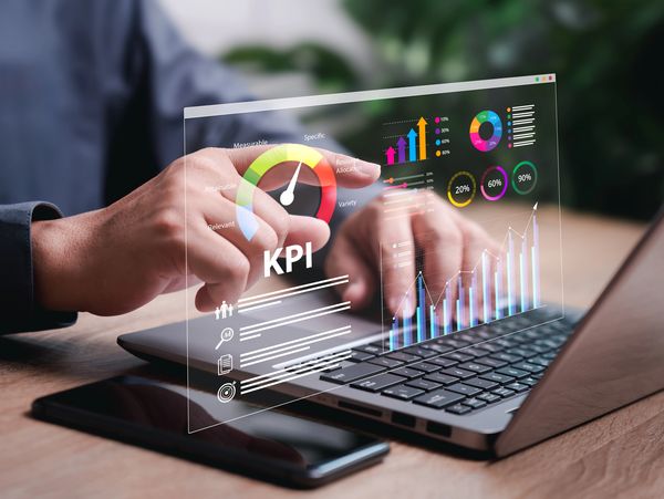 Person analyzing KPI dashboard with colorful graphs and charts on a laptop.