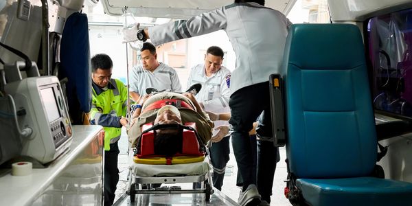 Emergency responders loading a patient into an ambulance.