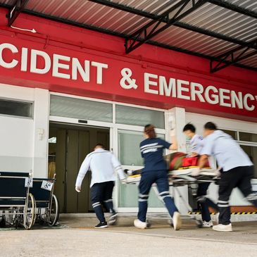 Medical staff rush a patient on a stretcher into the emergency room.