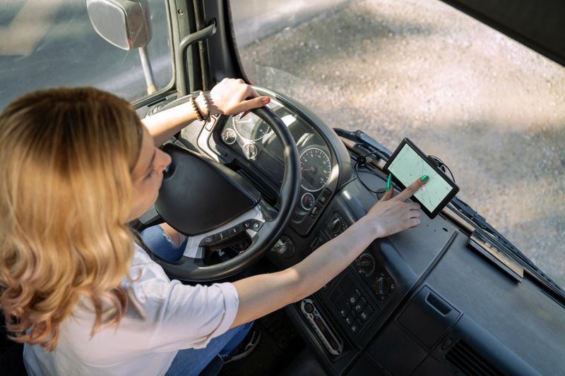 Woman truck driver using navigation, entering data