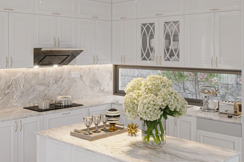 Open Concept Elegant and Spacious Kitchen with Marble Countertops, flowers with glass set on the counter