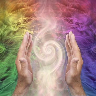 Reiki hands with a rainbow aura spiral, symbolizing gentle energy balancing.