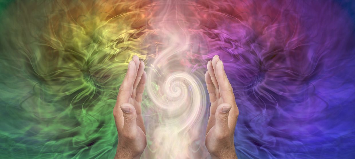 Hands surrounding a colorful swirling energy.