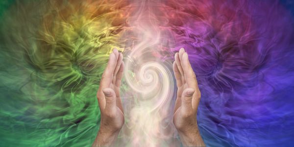 Hands channeling colorful swirling energy in a mystical aura. The image depicts the energy that is flowing as it is used in Divine Quantum Reiki. Energy Therapy is one of many healing modalities.