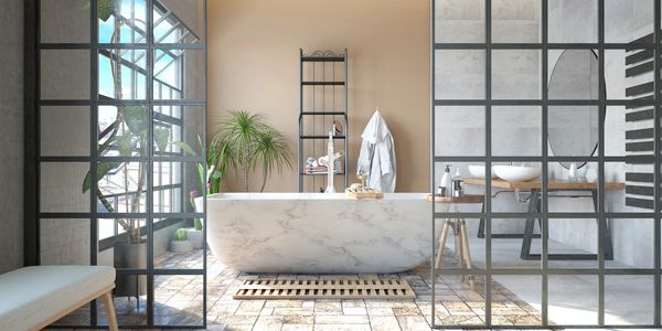 Modern bathroom with a marble bathtub and glass partition walls.