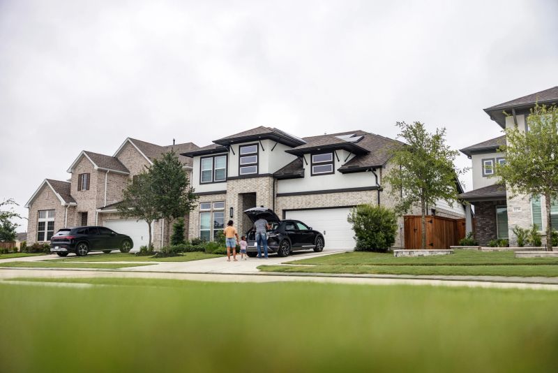 A joyful multiethnic family arrives home and charges their electric vehicle (EV) in front of their house equipped with solar panels. The scene depicts sustainable living and togetherness