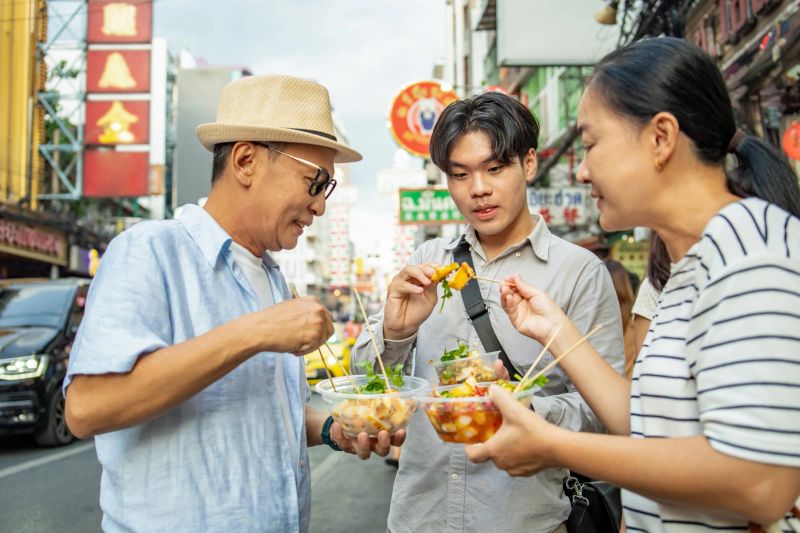 adult family with senior parents traveling and eating street food together at bangkok chinatown area