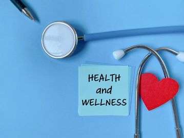 Stethoscope with a red heart and note saying Health and Wellness.