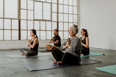 Group meditating together on yoga mats indoors.