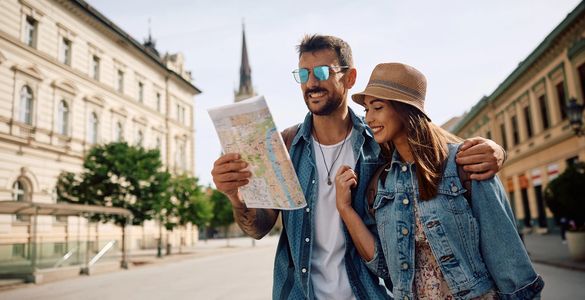 Couple exploring a city, reading a map together on a sunny day.