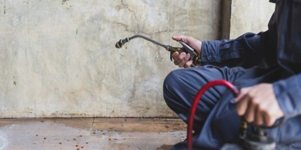 Person holding a welding torch and hose.