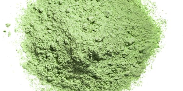 Powdered green matcha tea on a white background.