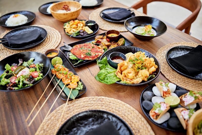 High angle view of various foods in plates arranged on dining table at resort