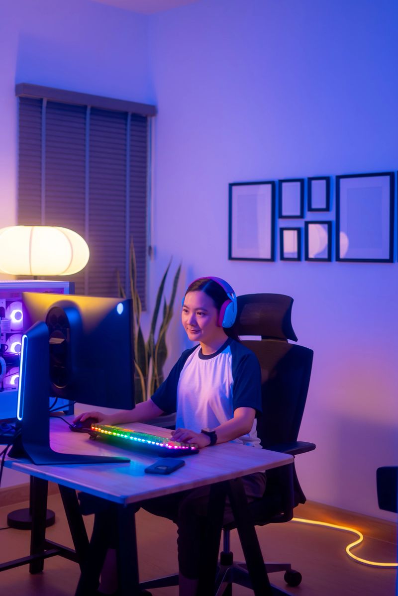 Asian woman gamer wearing headset happy enjoy playing computer game in gaming room at home.