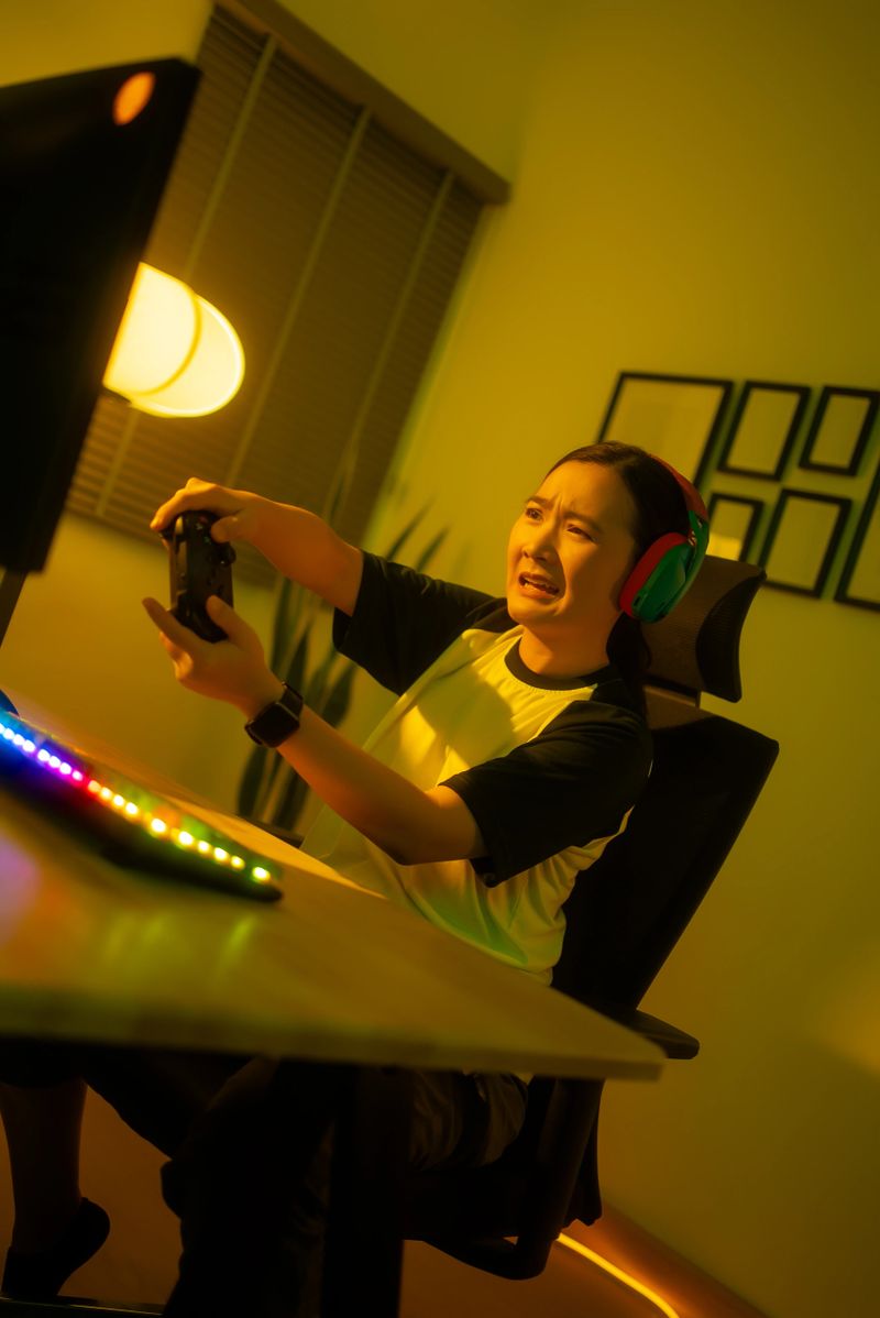 Asian woman using joystick playing computer game feeling upset after lose in game sitting in gaming room at home.