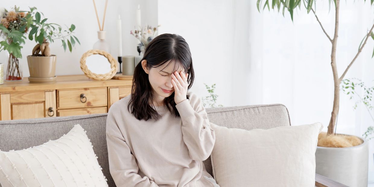 Woman experiencing dry eyes while sitting on a couch – San Carlos Eye Care Dry Eye Quiz
