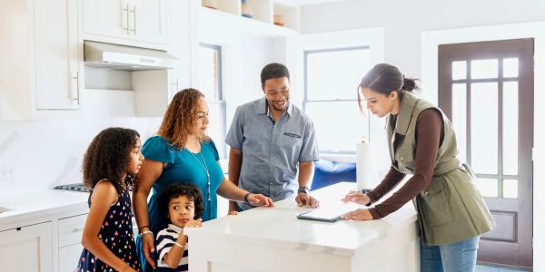 Real estate agent showing a family a house plan.