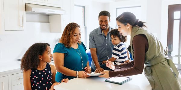 A family consulting with a professional in a bright kitchen.