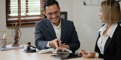 Two lawyers discussing a case with legal books and gavel on the desk.