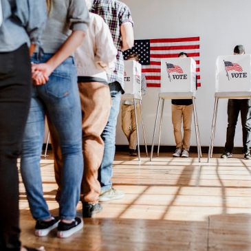 People waiting in line to vote in a polling station.