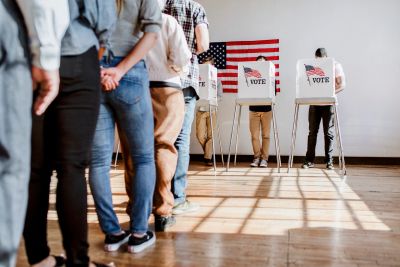 People voting in booths at a polling station.
