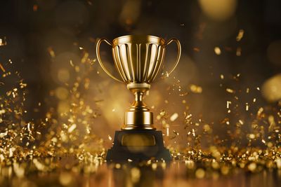 Golden trophy with confetti.