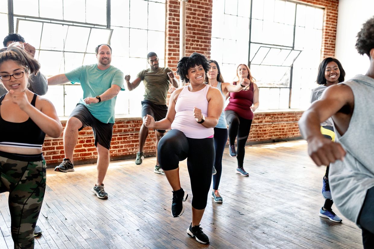 A diverse group exercising together in a bright studio.
